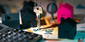 A calculator, keychain, and house model on a table