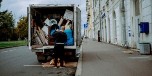 a man unloading furniture from the back of a moving truck